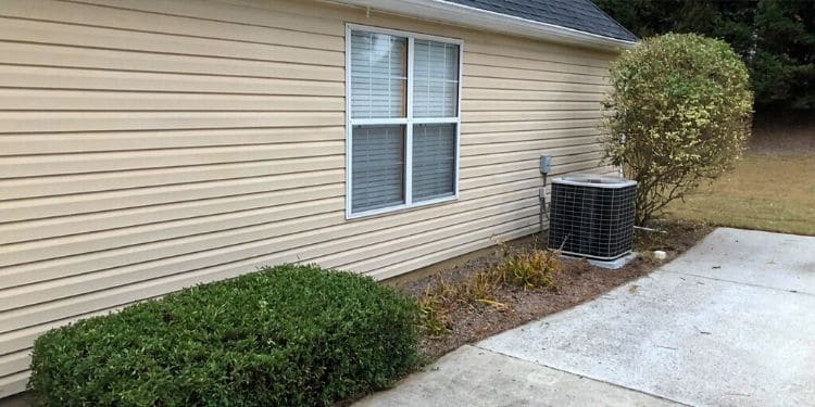 Well trimmed side landscaping bed by driveway and air conditioner.